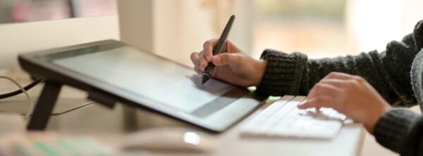 Graphic designer working with drawing tablet and computer keyboard